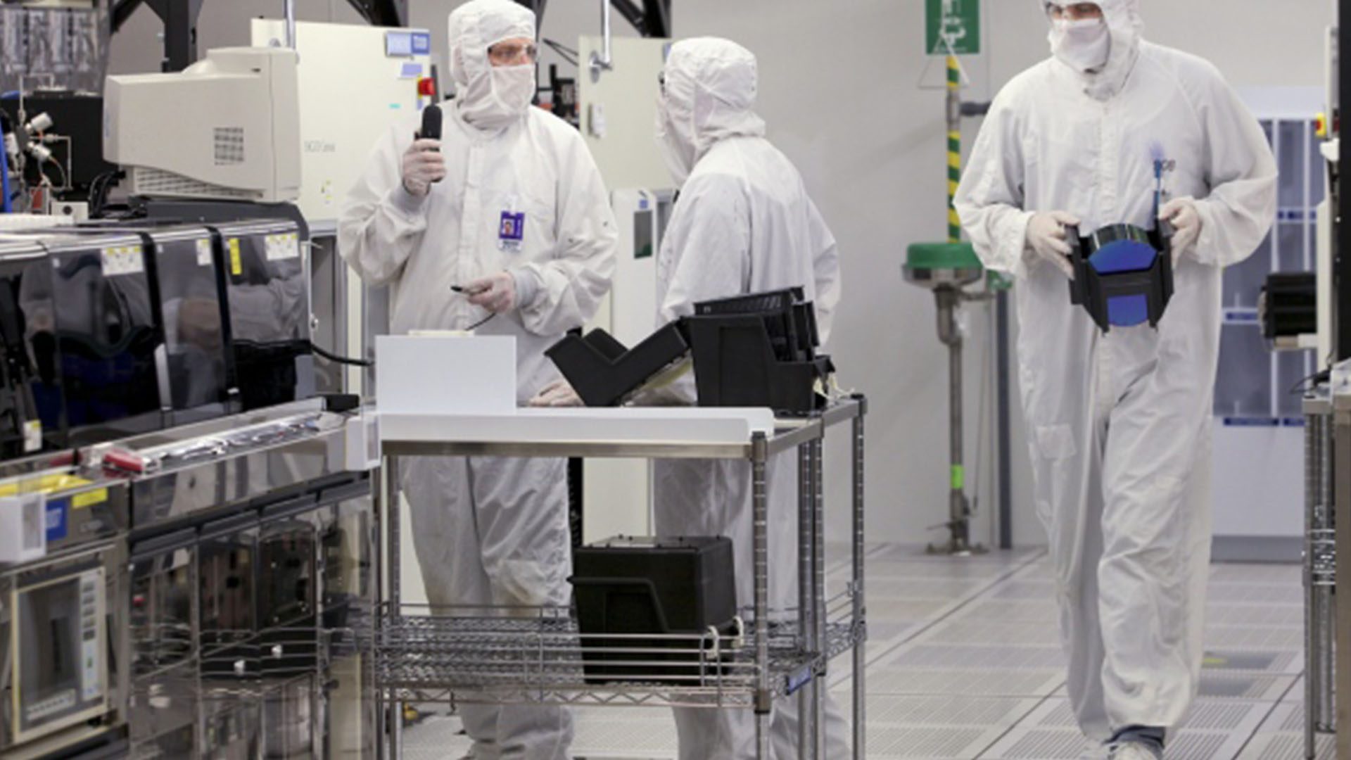 Workers prepare to load a silicon wafer machine in a clean room at the Texas Instruments semiconductor fabrication plant in Dallas, Texas as a response to the microchip shortage